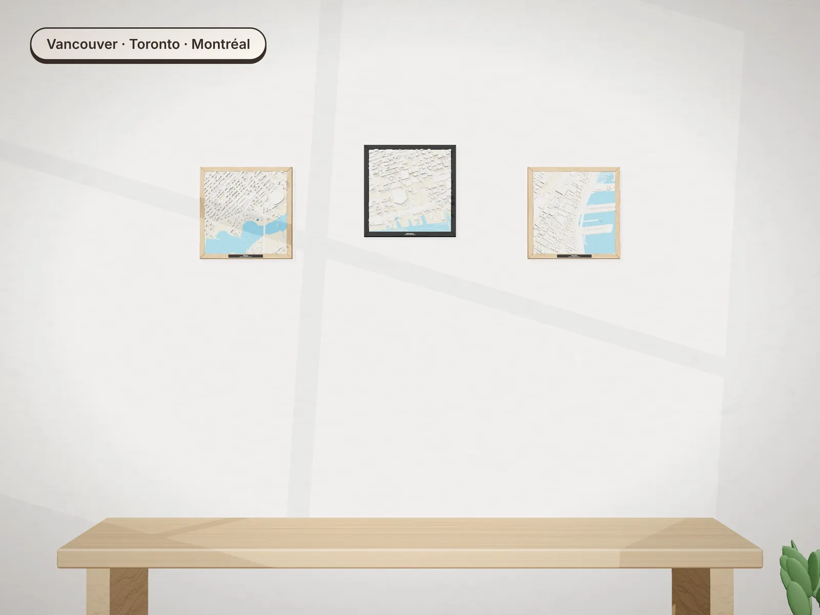 Three framed models of Vancouver, Toronto and Montréal over a bench